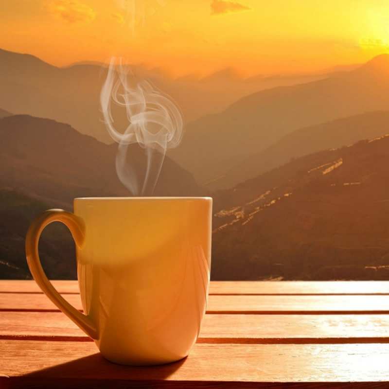 Открытка желтая кружка и пар  кофе в горах  Доброго ранку 
